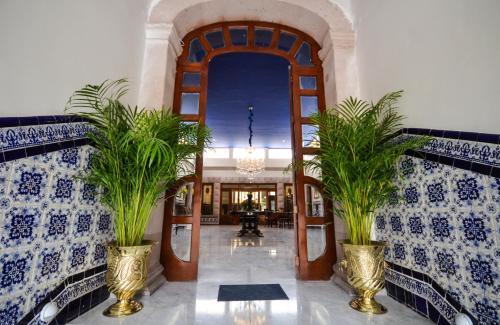 a hallway with two potted plants in a building at Hotel Boutique Casa del Jardín Aguascalientes in Aguascalientes