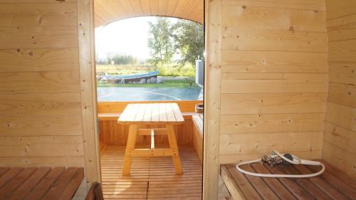 una sauna de madera con banco y mesa en Šventojoje nameliai Žibų 99, en Šventoji