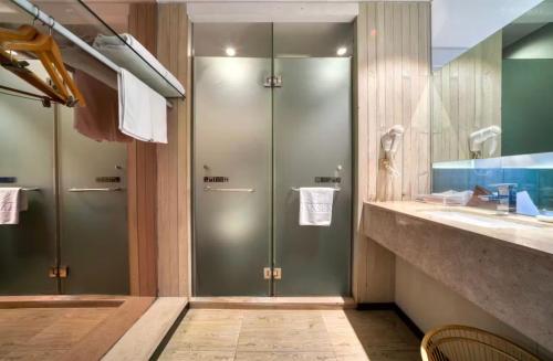 a bathroom with two shower stalls and a sink at Hansen Hotel in Hangzhou