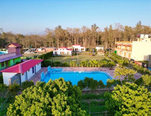 an aerial view of a resort with a pool and buildings at Hotel Corbett Bunglow By Food Bunglow in Rāmnagar