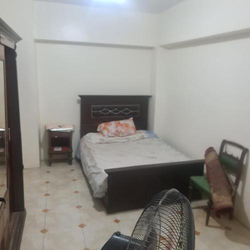 1 dormitorio con 1 cama y 1 silla en شقة مفروشة غرفتين بمدخل مستقل en Kafr Abū Dabbūs