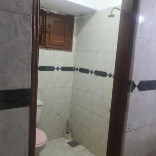 uma casa de banho com um WC e uma cabina de duche. em شقة مفروشة غرفتين بمدخل مستقل em Kafr Abū Dabbūs