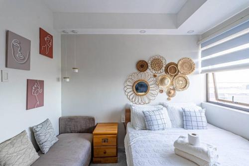 a living room with a couch and a mirror at Condo • WIFI up to 100mbps • Infinity Pool in Cebu City