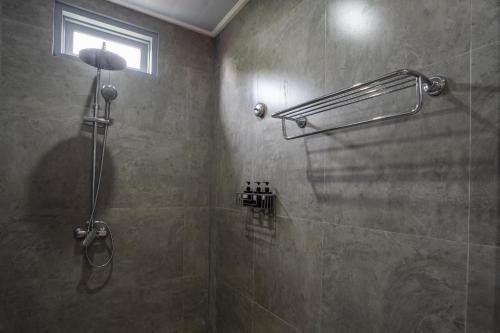 a bathroom with a shower with a glass door at The Peacock Inn in Ubud