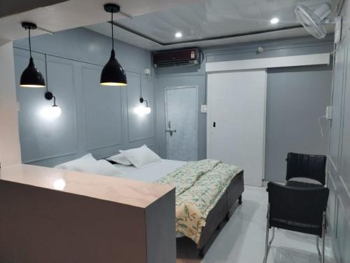 1 dormitorio con cama, silla y luces en Janki Kunj Varanasi- 3 Room Home, en Varanasi