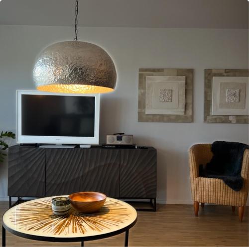 a living room with a table and a tv at Fewo Spectrum in Überlingen