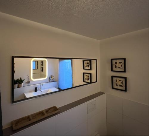 ein Bad mit einem Waschbecken und einem Spiegel in der Unterkunft Fewo Spectrum in Überlingen