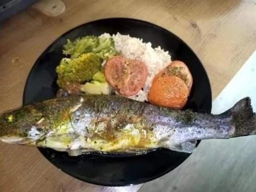 un plato de comida con pescado y arroz en Chambre pour 2 personnes avec un lit, en Chef-Boutonne