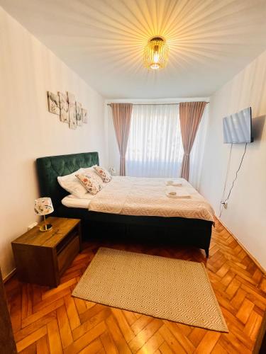 a bedroom with a bed and a window and a rug at Apart Relax Turda in Turda