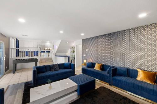 sala de estar con sofás azules y pared en Heated Pool - Poker - 5 min - Airport - 10-Strip, en Las Vegas