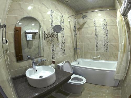 łazienka z umywalką, toaletą i wanną w obiekcie CARAVAN PLAZA BOUTIQUE w mieście Buchara