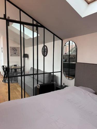 ein Schlafzimmer mit einem Bett und einem Schreibtisch in einem Zimmer in der Unterkunft Loft chic climatisé proche château de Vincennes in Montreuil