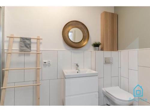 uma casa de banho com um WC, um lavatório e um espelho. em Glamour Apartment em Gdansk