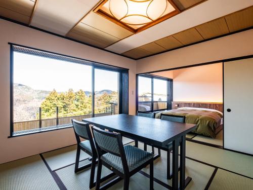 a room with a table and chairs and a bedroom at Nagominoyado Hanagokoro - Reopening in Mar 2024 in Hakone