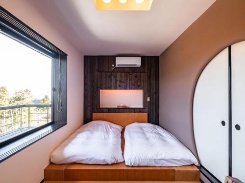 a small bedroom with a bed and a window at Nagominoyado Hanagokoro - Reopening in Mar 2024 in Hakone