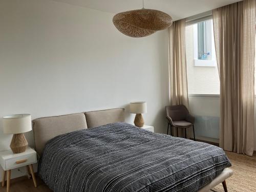 Appartement de charme + parking centre-ville Arras في أراس: غرفة نوم بيضاء بها سرير ونافذة