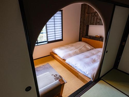 a bedroom with a bed and a mirror at Nagominoyado Hanagokoro - Reopening in Mar 2024 in Hakone