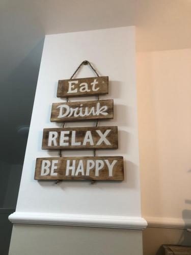 a sign that says eat drink relax be happy at ANCORA...IO E TE in Focene