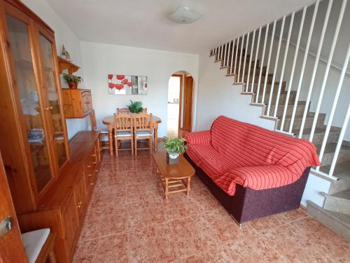un soggiorno con divano rosso e tavolo di Adosado con garaje privado - Junto al mar a Los Nietos