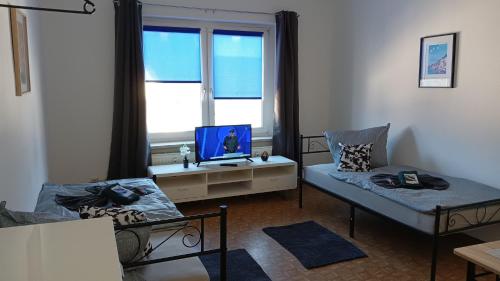 ein Wohnzimmer mit einem Bett und einem TV in der Unterkunft Stellas Monteurwohnungen in Crimmitschau