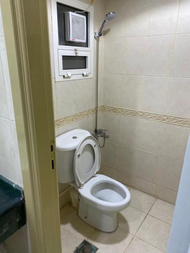 a small bathroom with a toilet and a window at The Family in Abu Dhabi