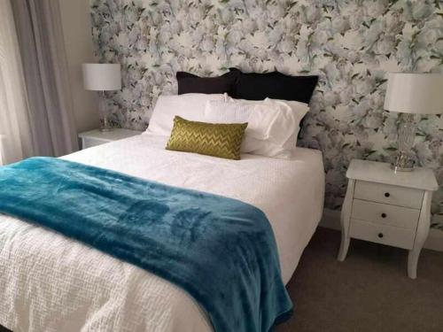 a bedroom with a bed with a blue blanket on it at Che Bella in Martinborough