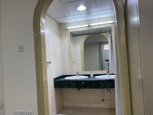 a bathroom with two sinks and a large mirror at The Family in Abu Dhabi