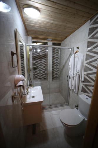 a bathroom with a shower and a toilet and a sink at Tessera Hotel in Sanlıurfa