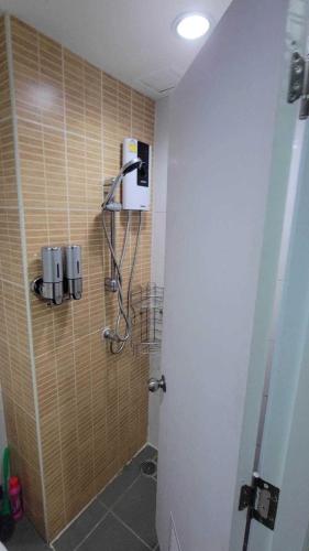 een badkamer met een douche en een glazen deur bij Lumpini Prachachaeun Great condo near Lumpini Park in Ban Bang Khen (1)