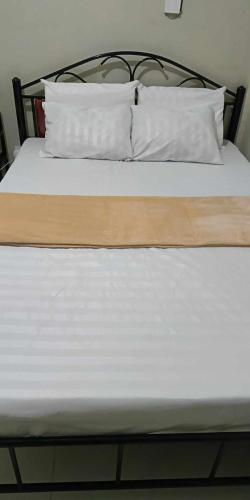 a bed with white sheets and pillows on it at Ck building apartment in Mabalacat