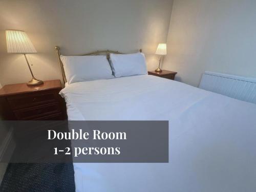 1 dormitorio con 1 cama blanca grande y 2 lámparas en Helen's Hotel en Londres