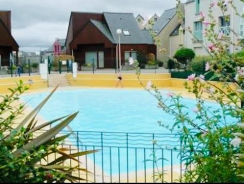 een groot zwembad met een persoon die in het water springt bij Bel Appartement Saint-Malo la Varde in Saint-Malo