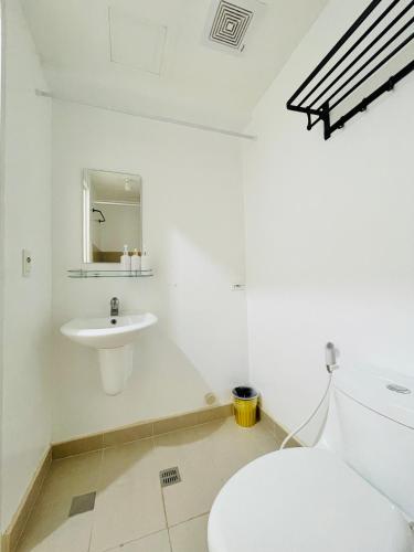 a white bathroom with a toilet and a sink at * *D2 Central Location Condo in Iloilo City