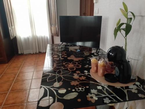 a glass table with a television on top of it at Claustro Home Casco Histórico Córdoba in Córdoba