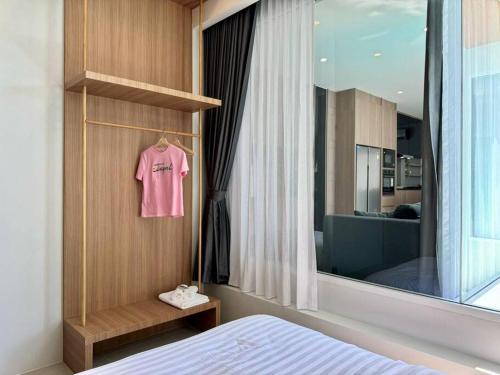 a pink shirt hanging on a wall next to a bedroom at Tarn’s pool villa Rawai in Ban Saiyuan (1)