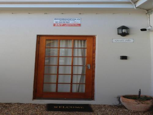 a wooden door on a white building with a sign at Hannah's Haven in Beaufort West