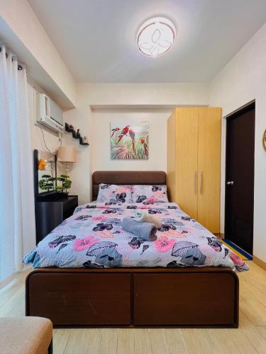 a bedroom with a bed with a colorful comforter at 2* * Contemporary Comfort in Iloilo City