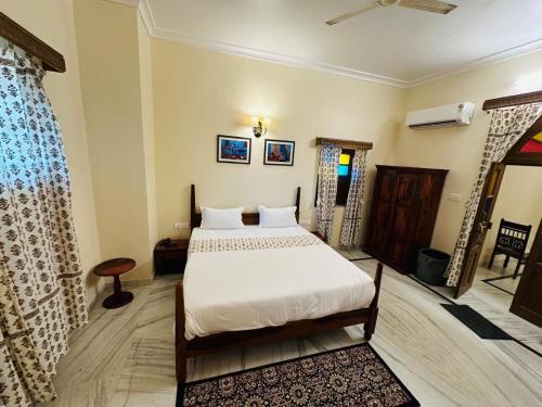 een slaapkamer met een wit bed in een kamer bij RAGHVENDRA HERITAGE in Jodhpur