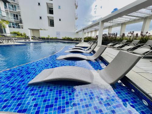 a pool with lounge chairs and a swimming pool at 2* * Contemporary Comfort in Iloilo City