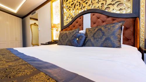 a bedroom with a large bed with a large headboard at Can Adalya Palace Hotel in Antalya
