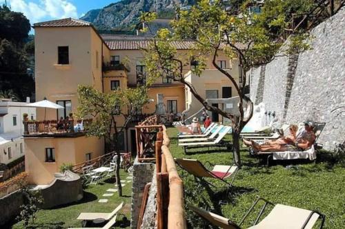 - une vue sur une cour avec des chaises et un bâtiment dans l'établissement Le Volte with pool by Amalfivacation, à Amalfi