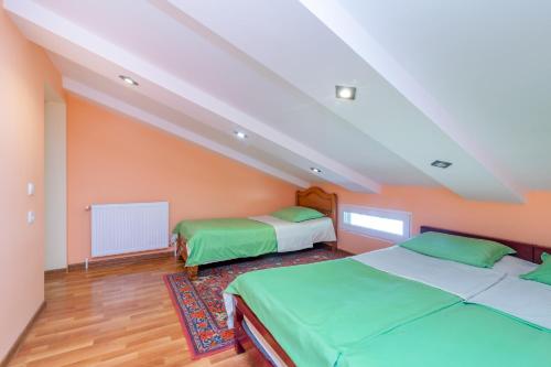 two beds in a room with orange walls at Mariana in Gori