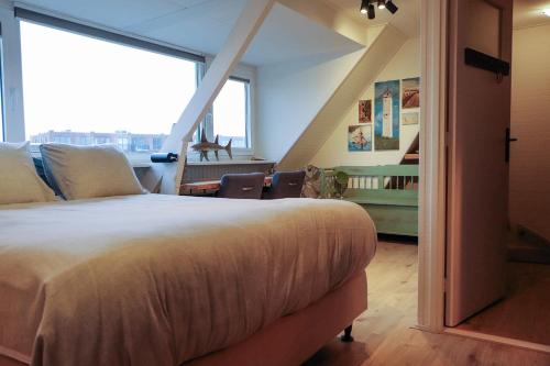 a bedroom with a large bed with a large window at Zee-en-Zo Noordwijk in Noordwijk