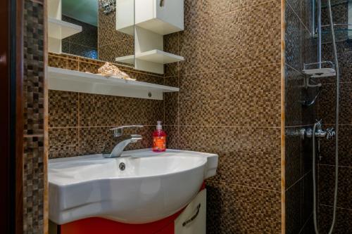 a bathroom with a white sink and a shower at Mariana in Gori