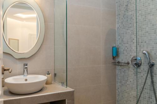 a bathroom with a sink and a glass shower at Nikolas Hotel in Karterados