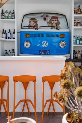 a vw bus sitting on a shelf with two stools at Nikolas Hotel in Karterados