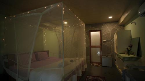 Patnem Palm Garden في بالوليم: غرفة نوم مع سرير مظلة في غرفة