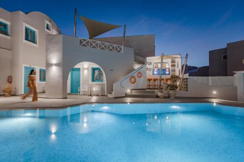 a person walking by a swimming pool in a house at Nikolas Hotel in Karterados