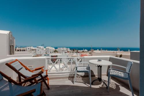 a balcony with chairs and a table and a view of the ocean at Nikolas Hotel in Karterados