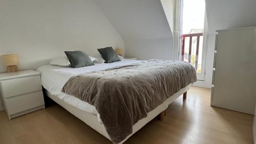 een slaapkamer met een bed met een deken erop bij Bel Appartement Saint-Malo la Varde in Saint-Malo